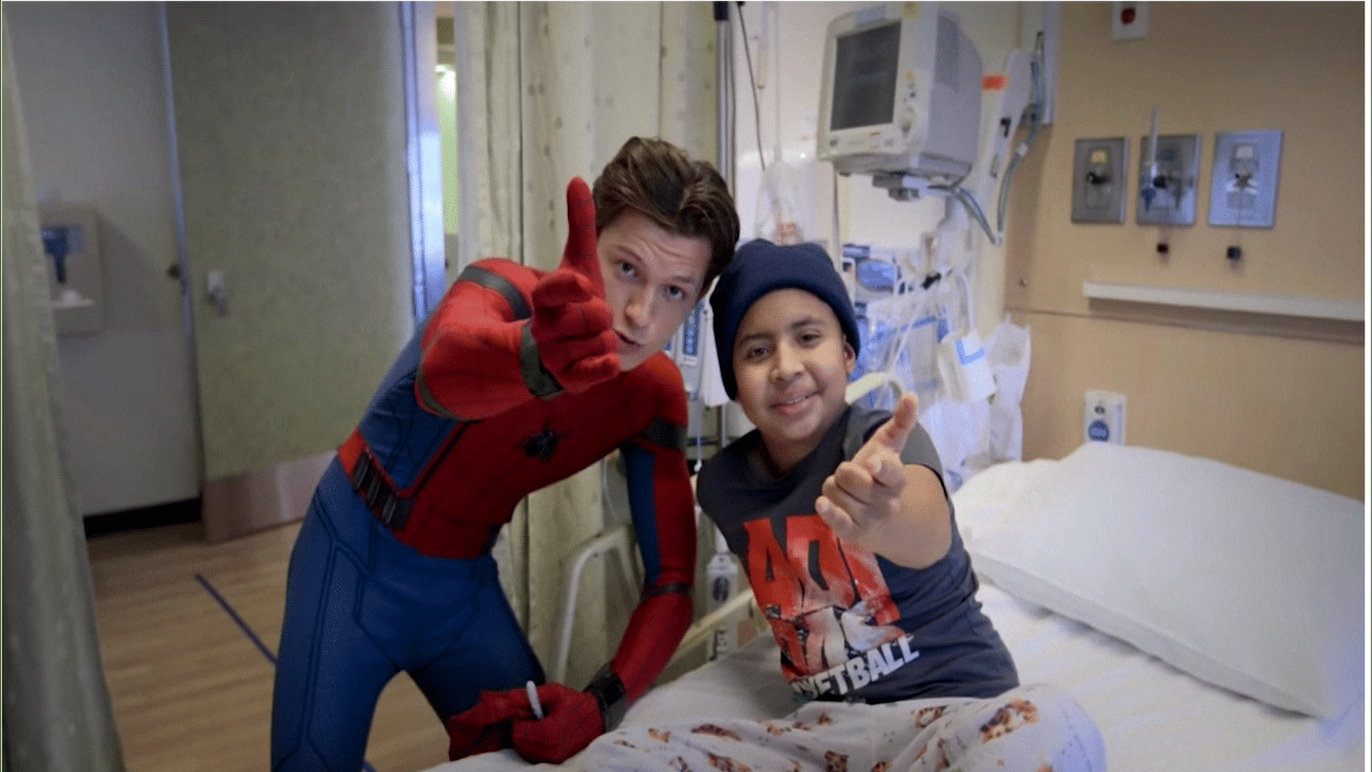 Tom Holland poses with a child at a hospital (Photo: AP screengrab)