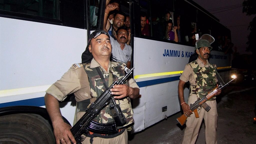 

Security personnel stand guard near a bus with Amarnath pilgrims aboard.