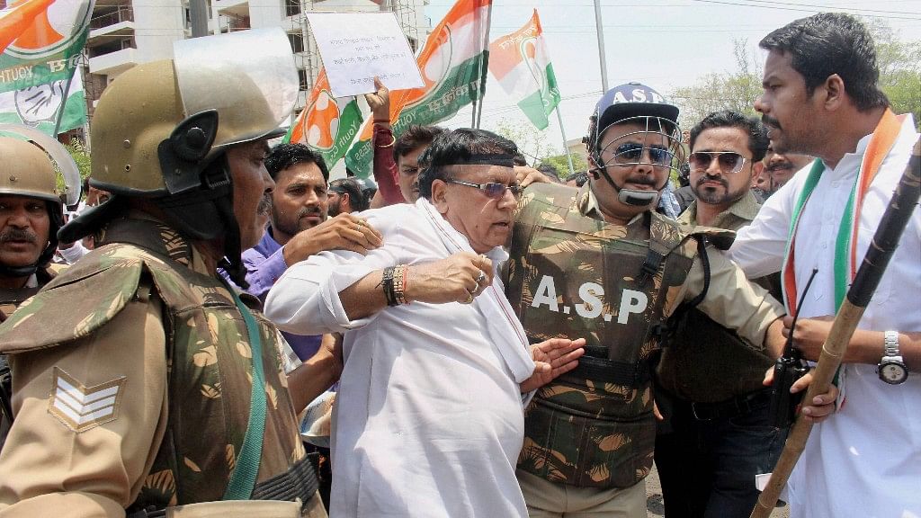 Police detain a Congress party activist demonstrating against CM Shivraj Singh Chouhan to protest against his indefinite fast, alleged as mockery of farmers, in Bhopal on Saturday. (Photo: PTI)