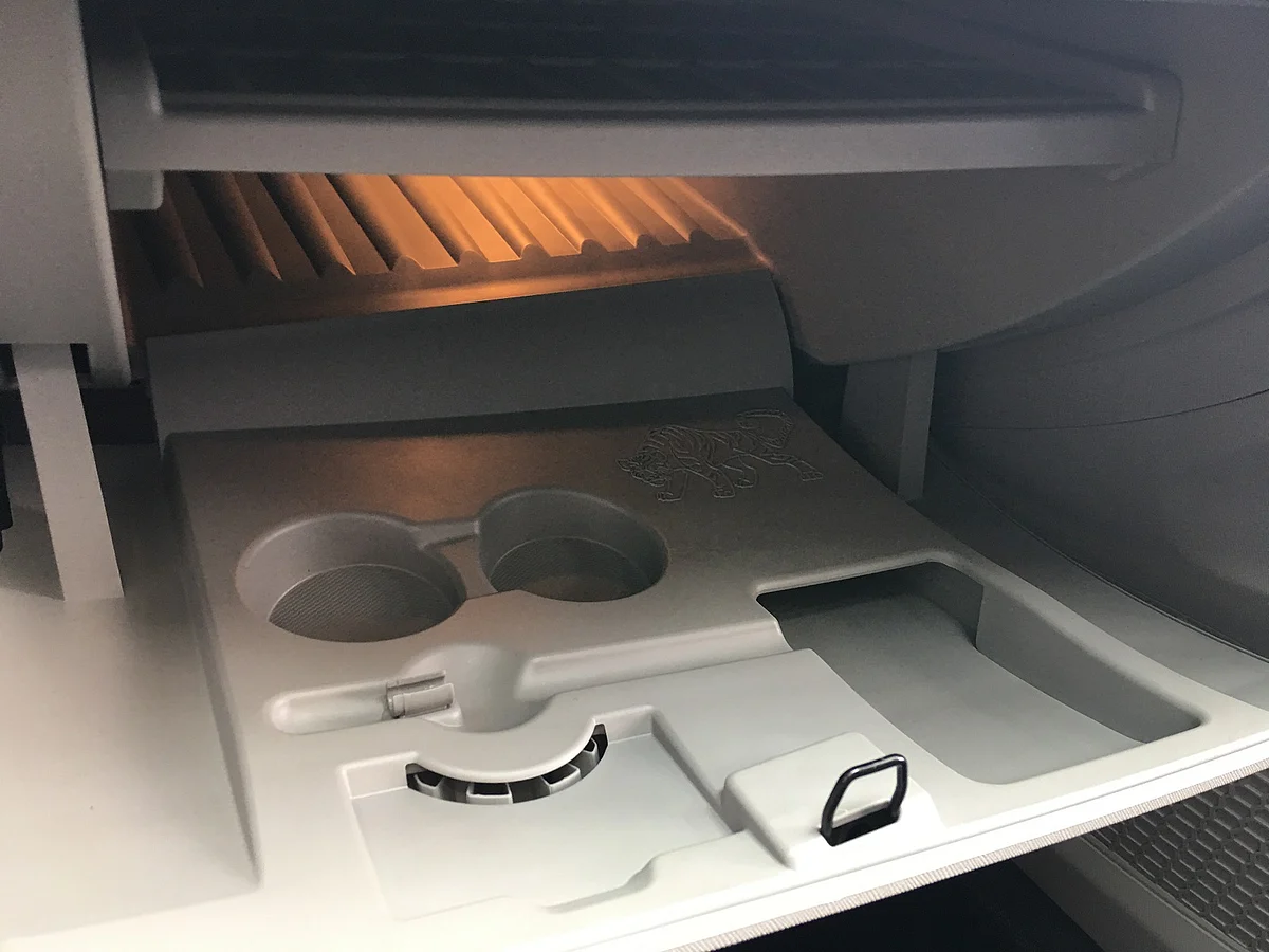 Utility spaces in the chilled glove box include pen holder, cup holders and place for a laptop. Note the embossed tiger. 