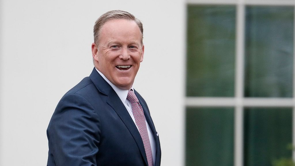 Outgoing press secretary Sean Spicer smiles as he departs the White House on Friday, 21 July.