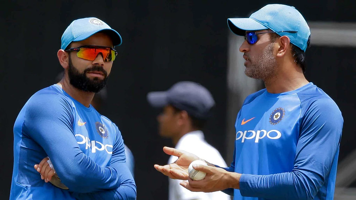 MS Dhoni (L) speaks to Virat Kohli (R) during a training session.