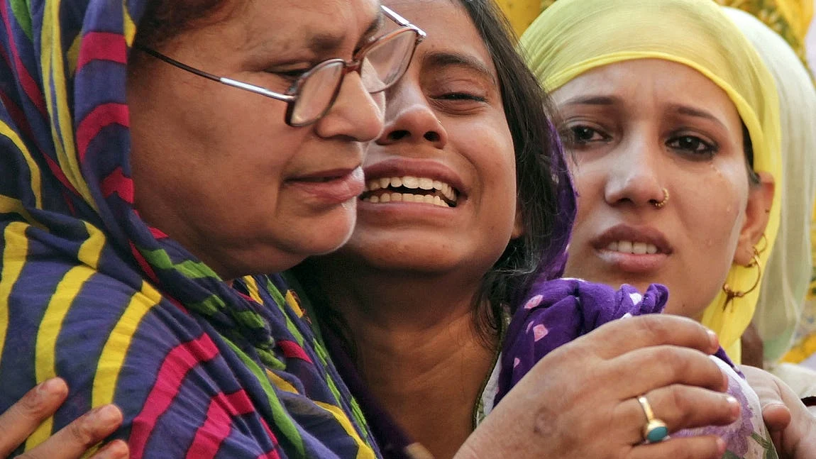Akhlaq’s 18-year-old daughter Shaista (centre) being consoled after her father Akhlaq’s death.