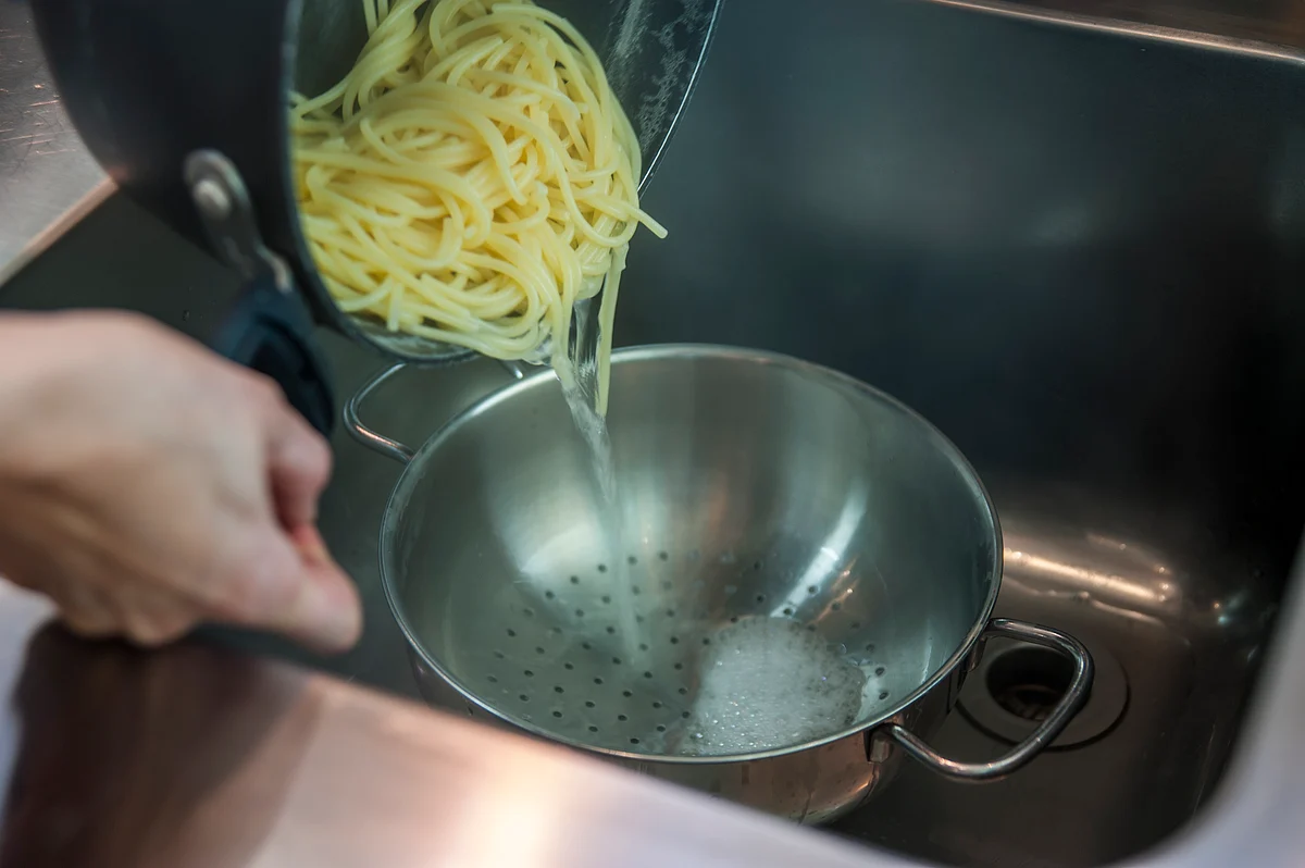 Washing off the cooked pasta will also wash off the starch and salt and make it flavourless and bland.