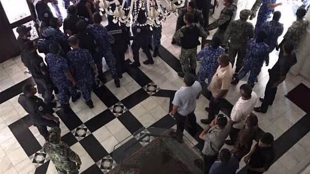 MPs being forcefully removed from the Maldives Parliament.