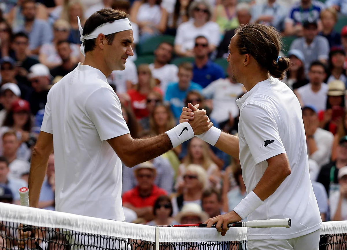 Switzerland’s Roger Federer, left, shakes hands with Ukraine’s Alexandr Dolgopolov after winning their Men’s Singles Match on day two at the Wimbledon