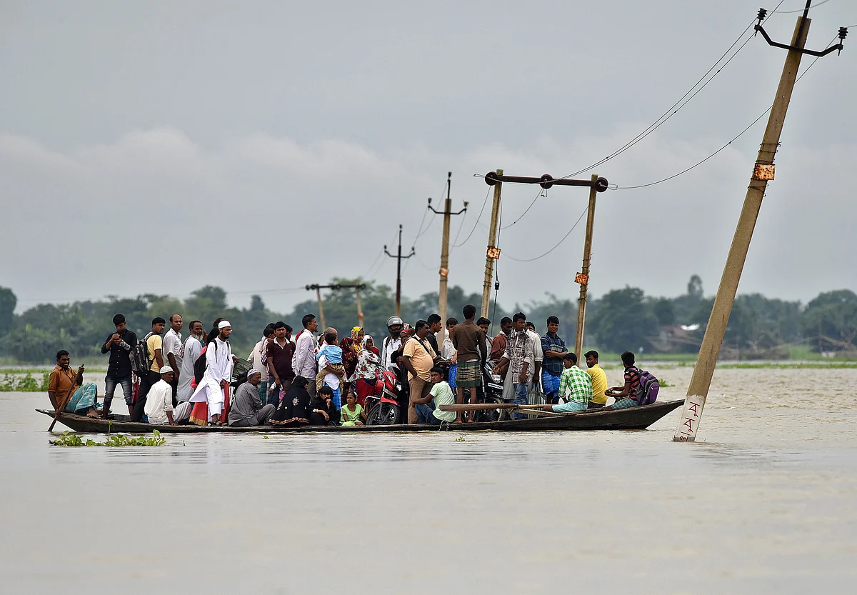 Villagers use a boat to cross a flooded road at Asigarh village in Morigaon district in the northeastern state of Assam. (Photo: Reuters)