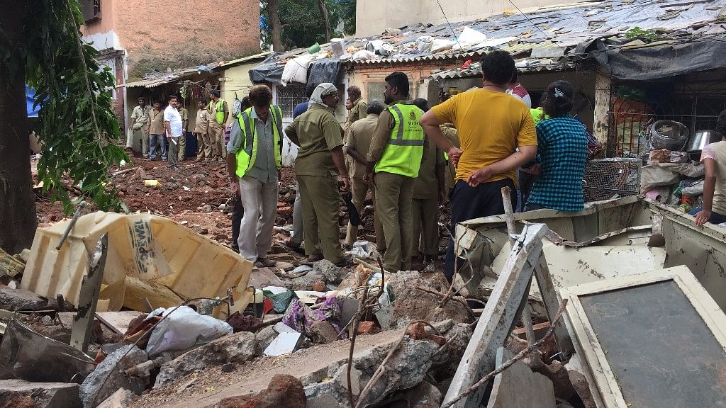 BMC workers rummage through debris for belongings of former residents.
