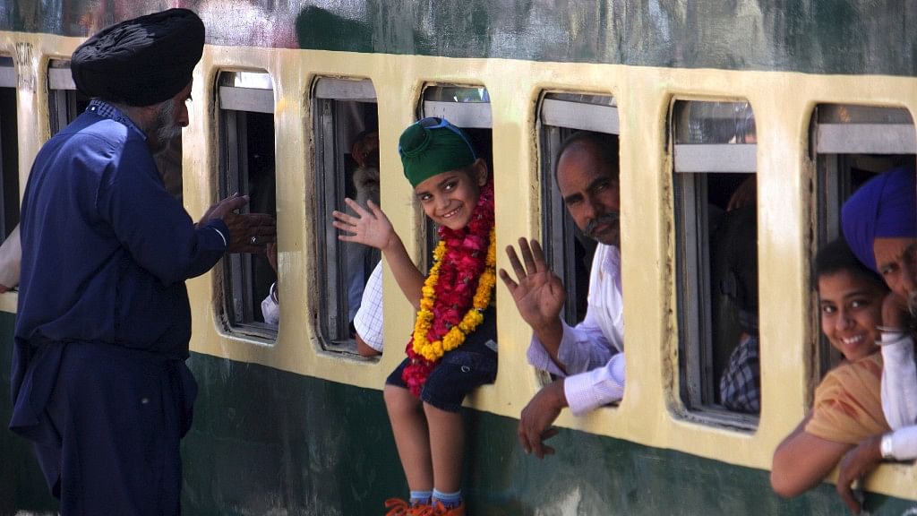 Indian Sikh pilgrims wave from a train as they arrive at Wagah Railway Station in eastern Pakistan’s Lahore, on 12 April 2017, to celebrate Baisakhi, or the Sikh New Year.