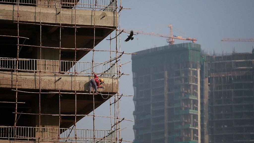 A labourer stands on wooden scaffolding as he works at the construction site of a commercial building in Mumbai’s central financial district, 16 January 2015.