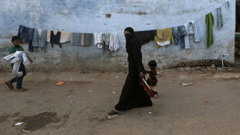 A Muslim woman and child walk through a locality of the Muslim dominated Johapura area in Ahmedabad.