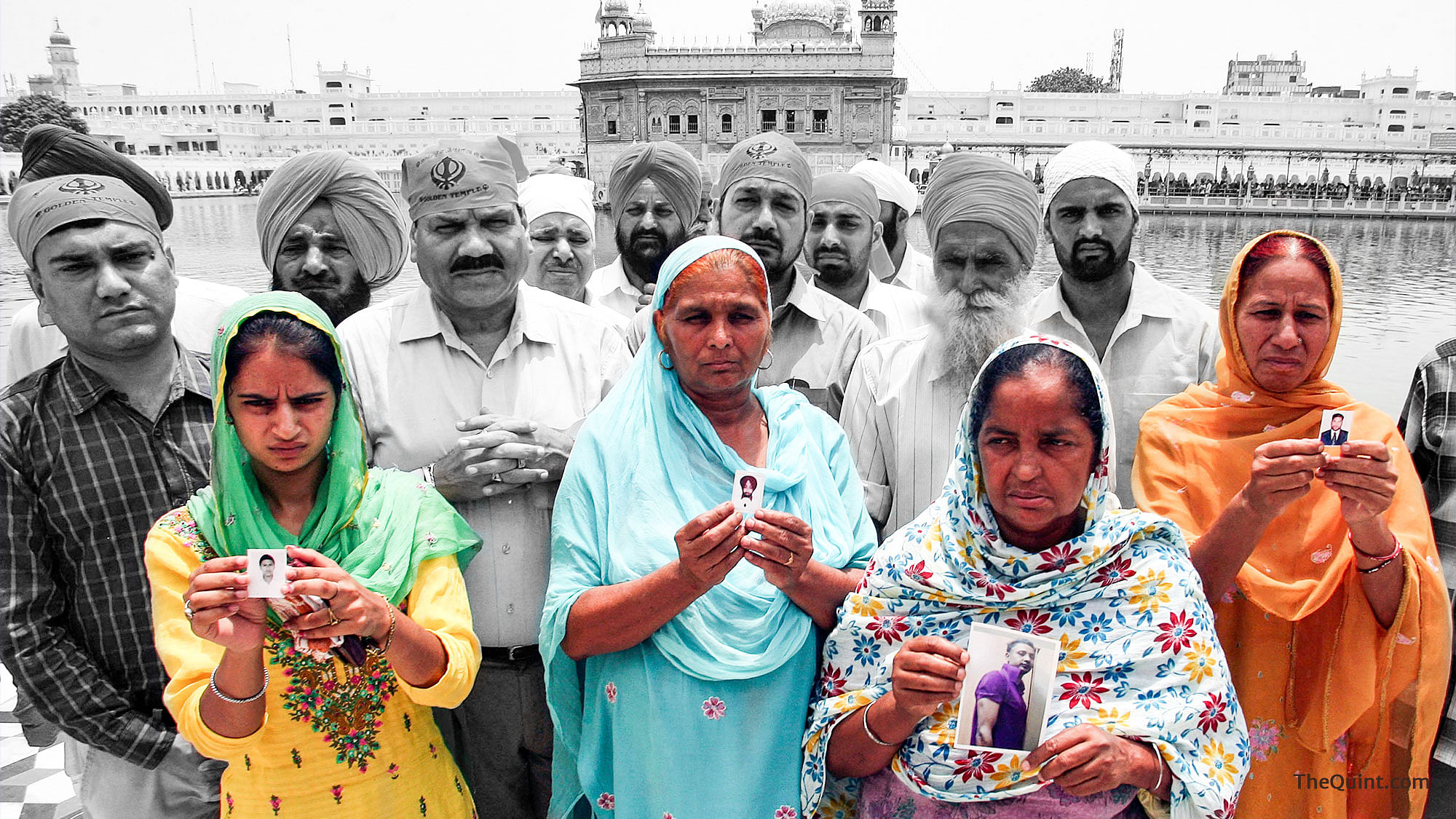 Relatives pose with the photographs of Indian workers, who have been abducted in Iraq, in front of the Golden Temple, 19 June 2014.