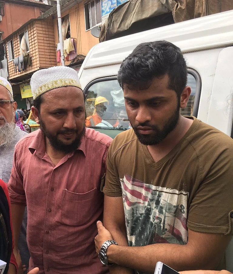 Mustafa Gangerdiwal waits next to the collapse site for information on his cousin.