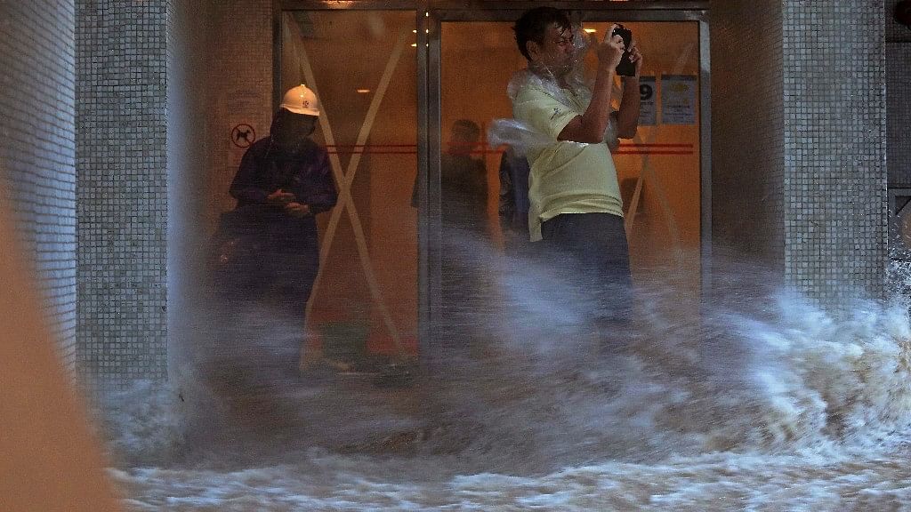A man takes pictures against strong wind caused by typhoon Hato at a housing area in Hong Kong