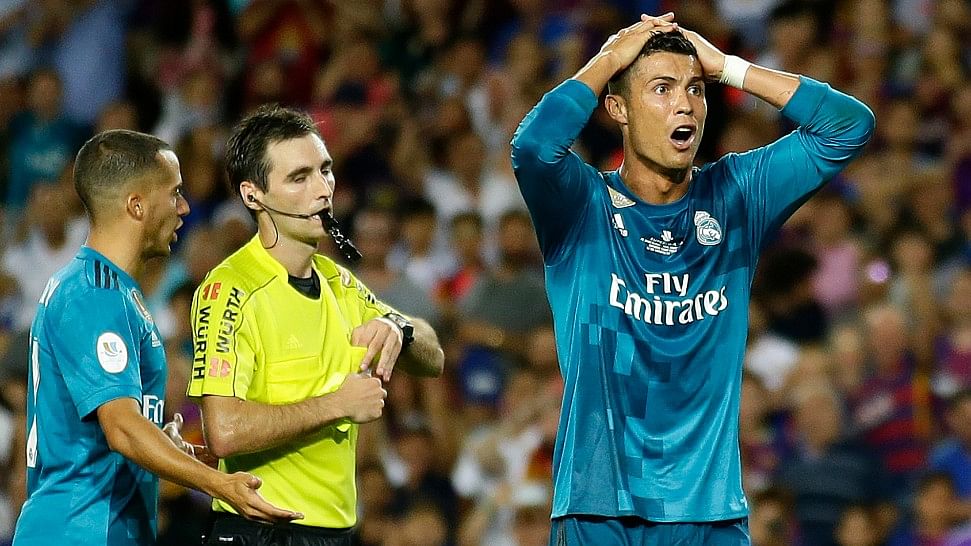 Real Madrid’s Cristiano Ronaldo, right, reacts after Referee Ricardo de Burgos shows a yellow card.