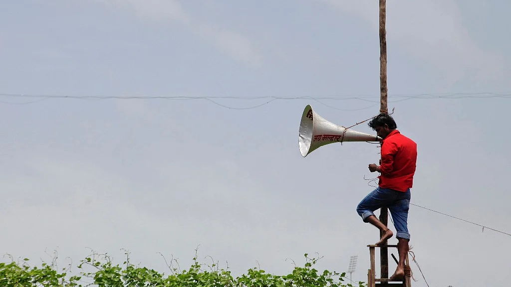 A worker fixes a loudspeaker in Mumbai.
