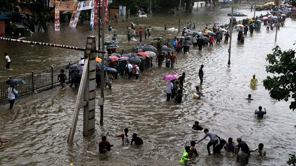People walk through a waterlogged street following heavy rains in Mumbai.