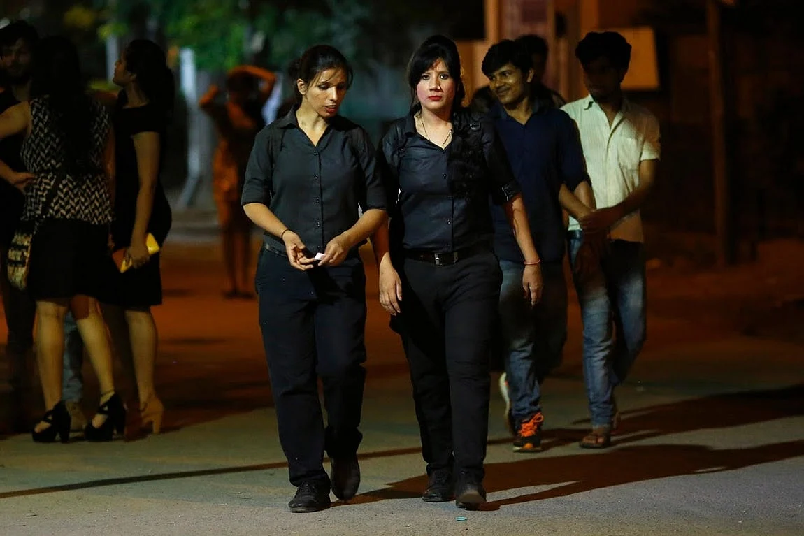 Bouncers and sisters, Mehrunnisha Shokat Ali (right) and Tarannum, walk towards a taxi after finishing their shifts.