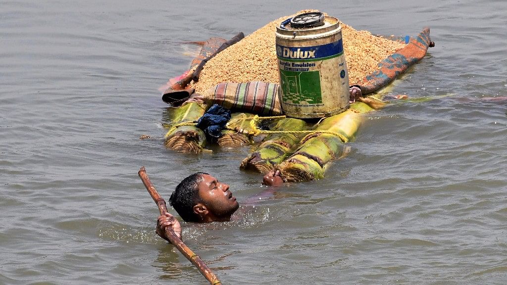 File image of a villager carries grains on a banana raft as he shifts from a flooded village in Araria district of Bihar.