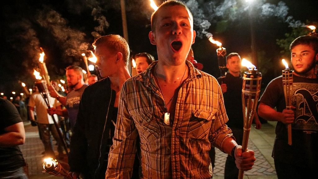 In this photo taken Friday, 11 August 2017, multiple white nationalist groups march with torches through the UVA campus in Charlottesville, Virginia. Hundreds of people chanted, threw punches, hurled water bottles and unleashed chemical sprays on each other Saturday after violence erupted at a white nationalist rally in Virginia.  &nbsp;