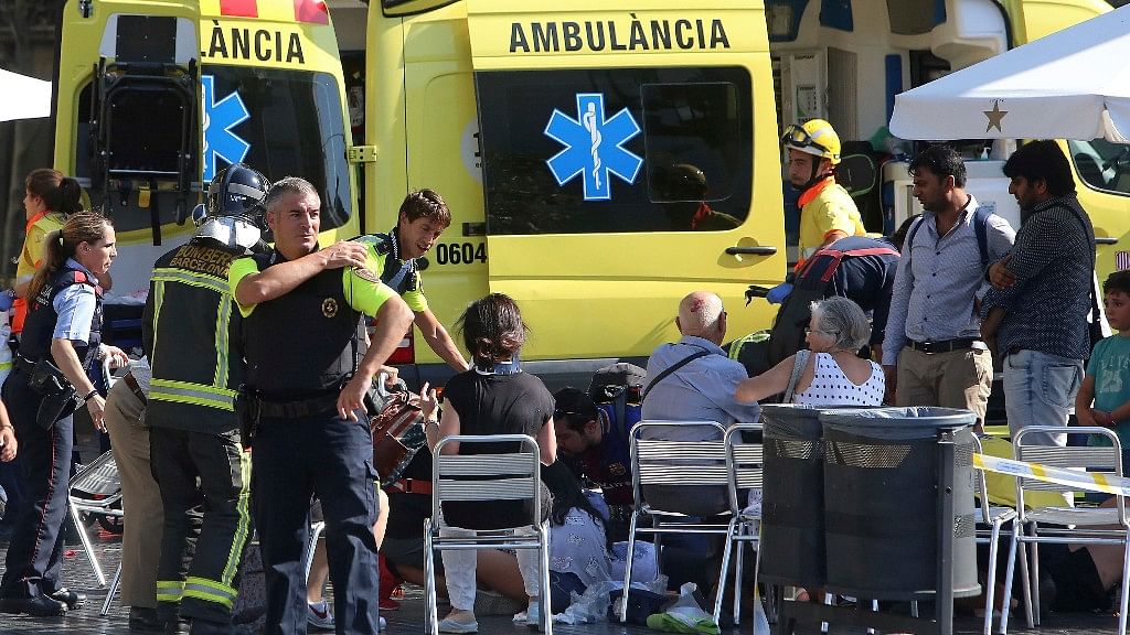 Injured people are treated in Barcelona, Spain on 17 August 2017 after a white van jumped the sidewalk in the historic Las Ramblas district.