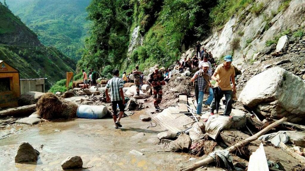 People walk towards a Kailash Mansarovar road after a cloud burst at Pithoragarh district in Uttarakhand on Monday.