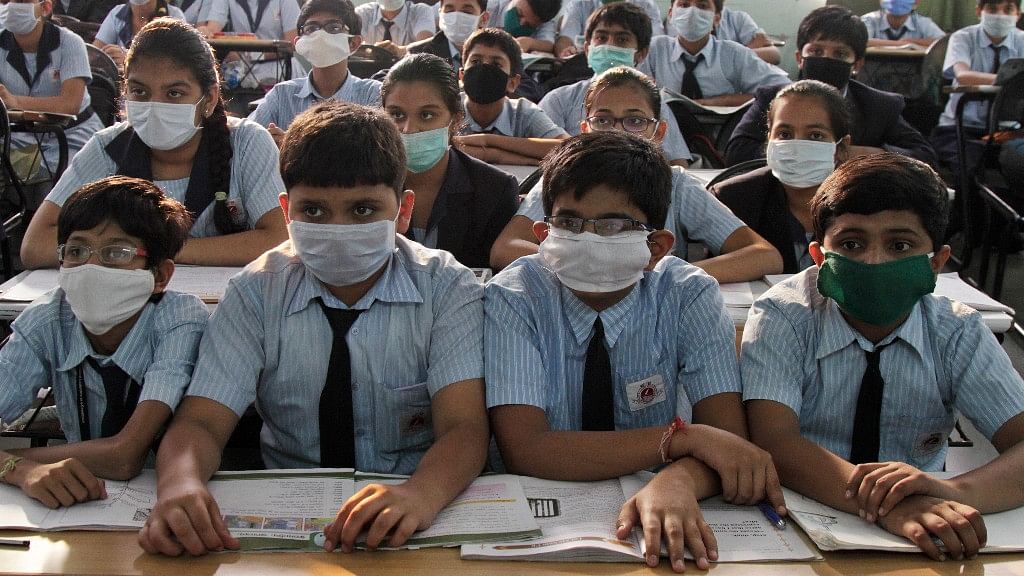 File photo of students wearing masks for protection against swine flu, as they attend their class at a school in Ahmadabad, Gujarat. (March 2015)