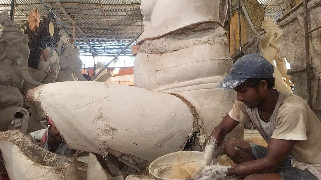 An idol-maker moulds a Ganesh idol at a workshop in Parel.