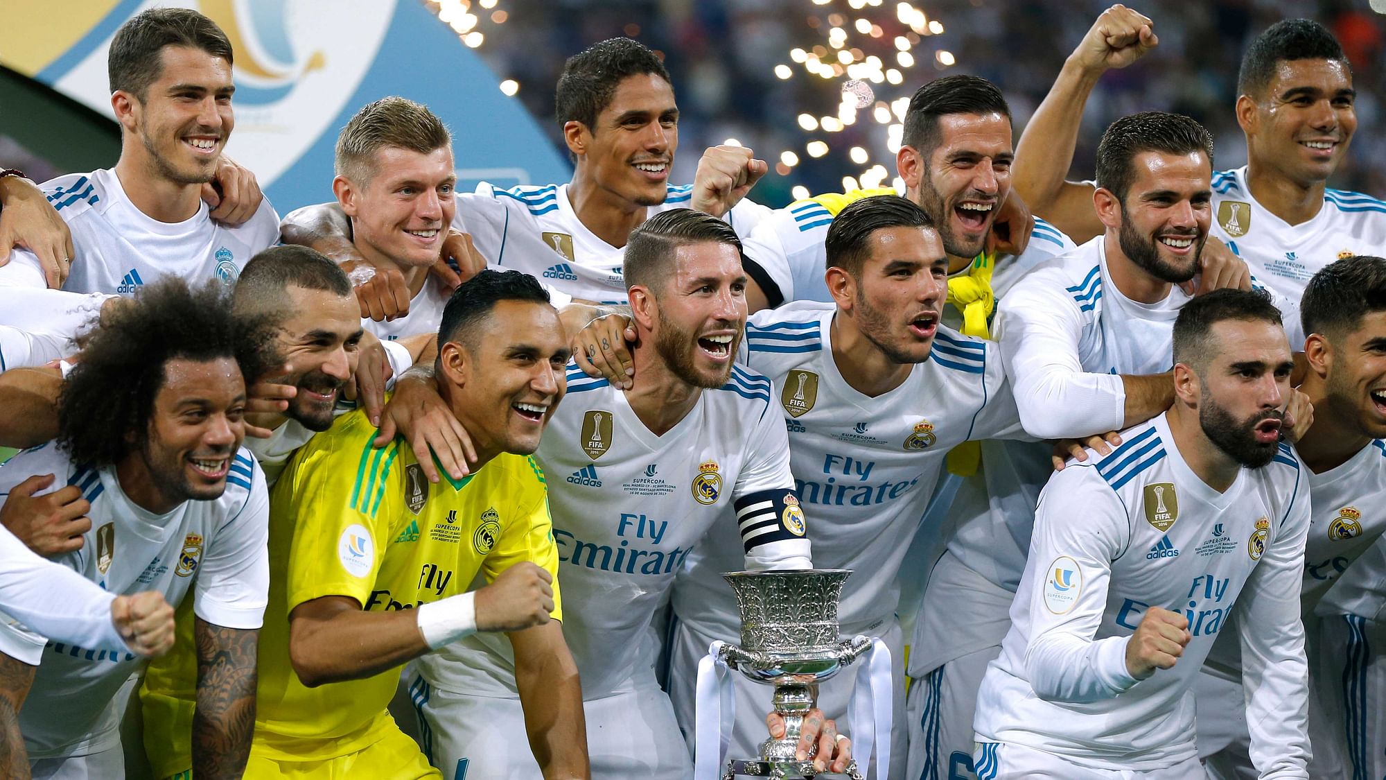 Real Madrid’s players celebrate with their trophy after winning the Spanish Super Cup against Barcelona at the Santiago Bernabeu stadium in Madrid