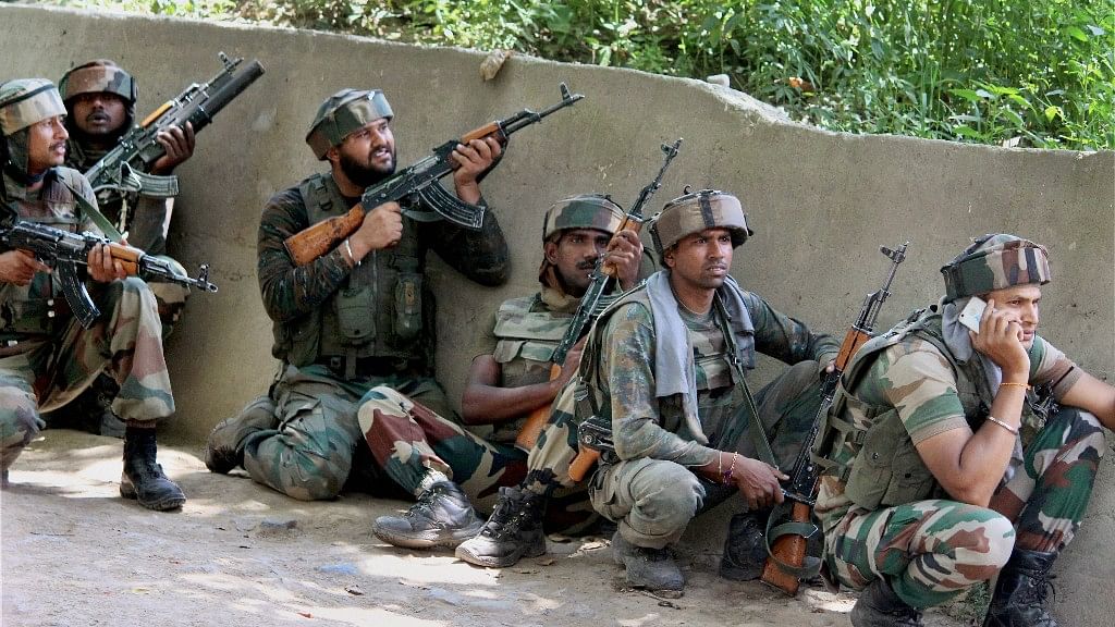  Army soldiers take positions outside a house where militants were hiding during an encounter in which top three Hizbul Mujahideen Commanders and two Army soldiers were killed, at Awneera in Shopian district of south Kashmir on Sunday.&nbsp;