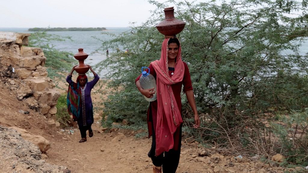 Women carry water home from Kalri lake in Thatta, Pakistan. Image used for representational purposes.&nbsp;