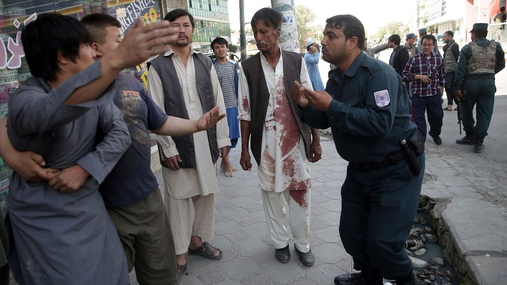 

A policeman asks an angry man to calm down during an ongoing attack on a Shiite mosque in Kabul.