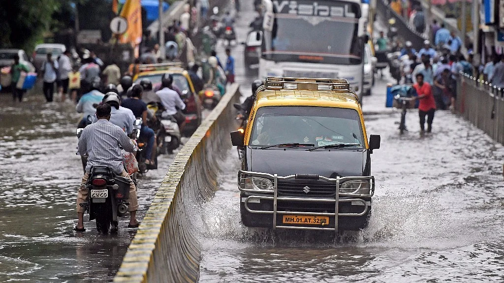 Vehicles plying at a waterlogged road after heavy rains in Mumbai.