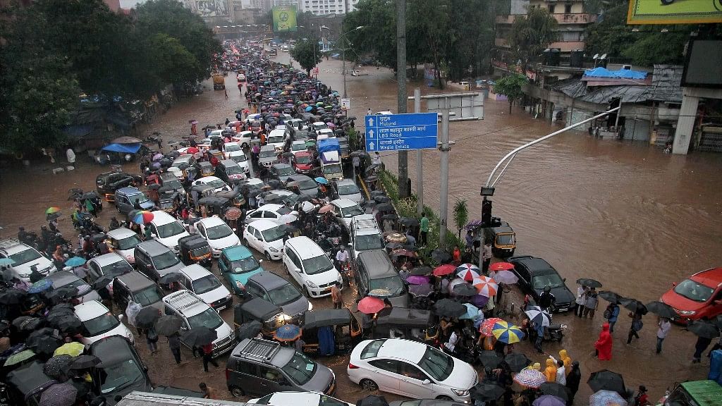 Vehicles stuck at a flooded street after heavy rains in Thane, Mumbai on Tuesday. 