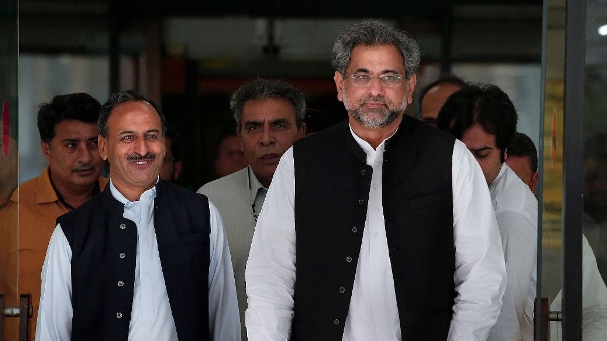 Pakistan’s PM Shahid Khaqan Abbasi (right) leaves with his aids after meeting with politicians in Parliament house in Islamabad, Pakistan.