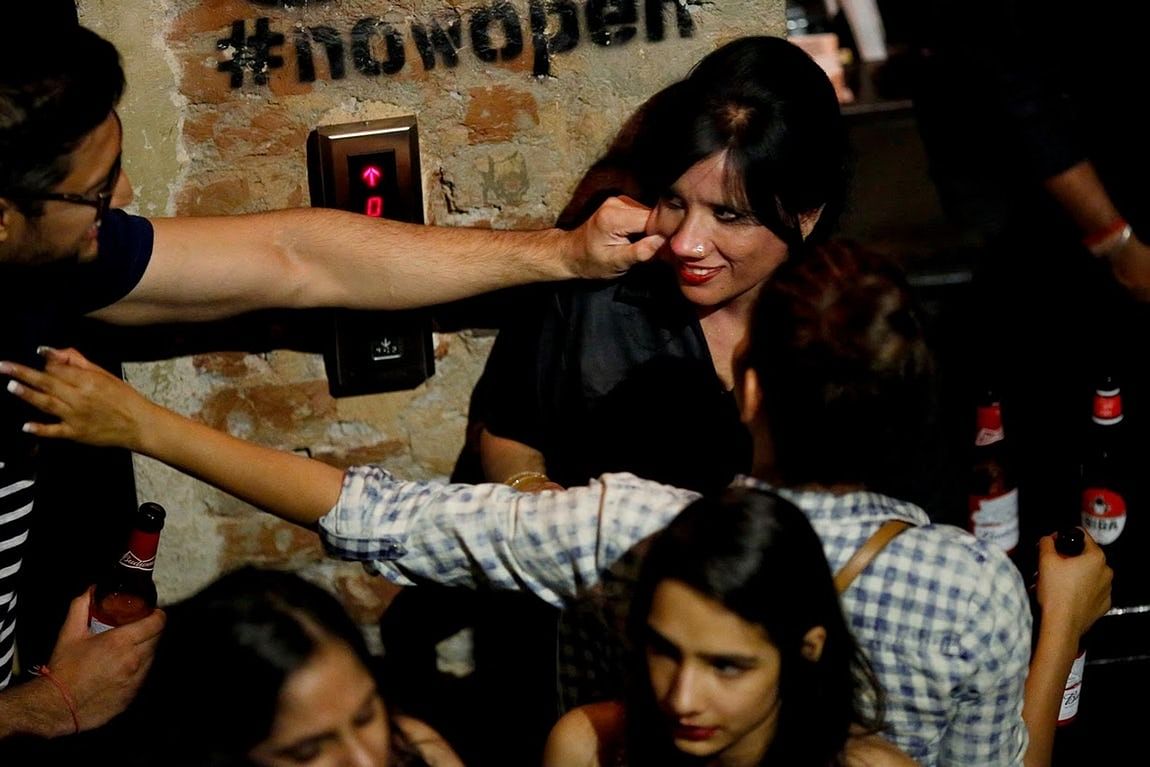 A man grabs cheek of bouncer Mehrunnisha at the dance floor of club Social in New Delhi.