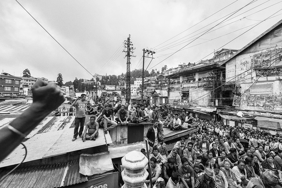 Locals listen to a leader during a rally conducted by Gorkha Janmukti Morcha (GJM), one of the major political parties from the hills, at Chowk Bazaar in Darjeeling.