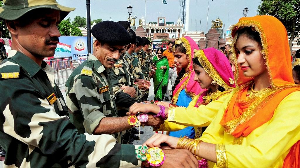 Students tie Rakhis on the wrists of BSF personnel in Amritsar on Monday.&nbsp;