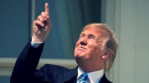 Trump looking at the eclipse without glasses.