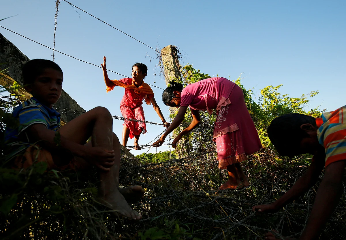 Rohingya children trying to cross the Bangladesh-Myanmar border fence as they try to enter Bangladesh in Bandarban, an area under Cox’s Bazar authority, Bangladesh.