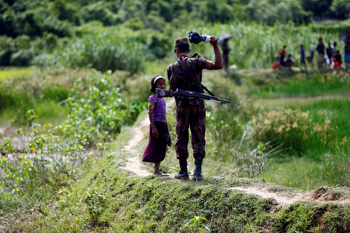 A member of the Border Guard Bangladesh (BGB) tells a Rohingya girl not to cross over to the Bangladesh side, in Cox’s Bazar.