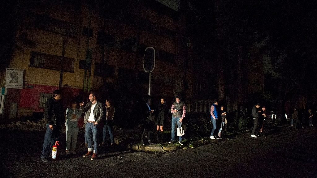

 People stand in a  street in the La Roma neighbourhood of Mexico City after the earthquake.