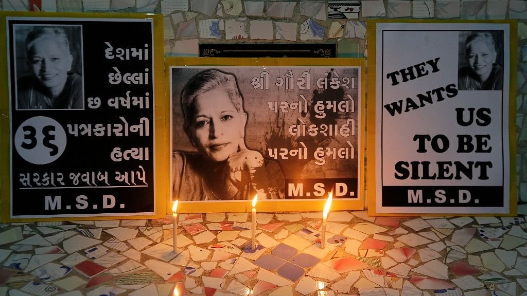 Candles burn in front of placards during a protest condemning the killing of Indian journalist Gauri Lankesh in Ahmedabad, India.