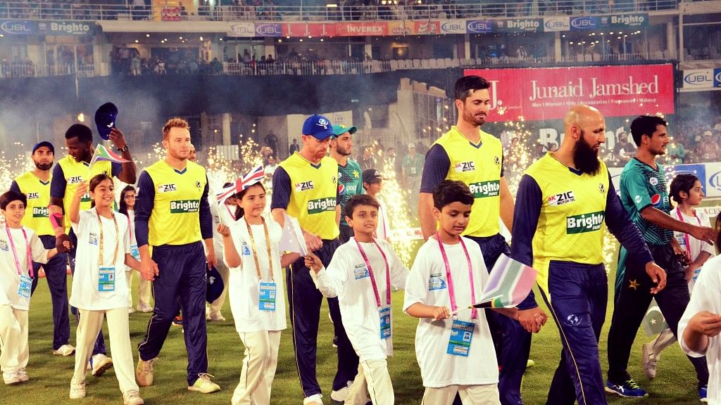 World XI players arrive on the pitch at the Ghaddafi Cricket Stadium to play against Pakistan’s team.