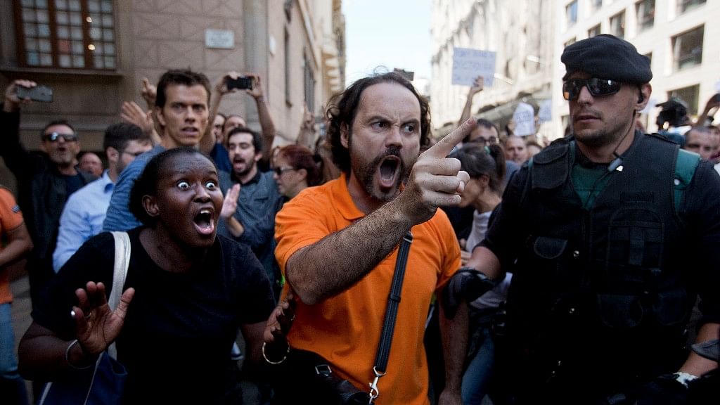 Demonstrators react as they try to stop the car carrying Xavier Puig, a senior at the Department of External Affairs, Institutional Relations and Transparency of the Catalan Government office, after he was arrested by Guardia Civil officers in Barcelona, Spain, on Wednesday.