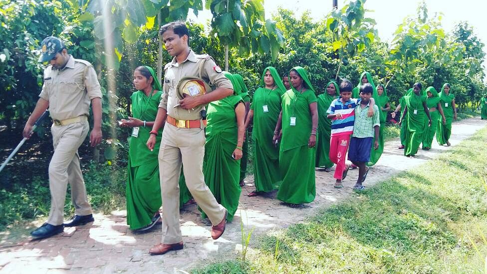 Sub-inspector Pawan Yadav accompanies the Green Gang as they walk around the village. Seeing the police with women has helped boost their confidence.