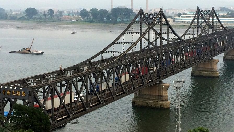 Trucks cross the friendship bridge connecting China and North Korea on 4 September 2017. Trump has threatened to cut off trade with countries that deal with North Korea.&nbsp;