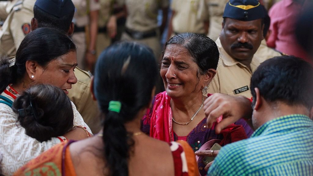 A family mourns outside a morgue for relatives killed in a pedestrian bridge stampede at Elphinstone station in Mumbai.