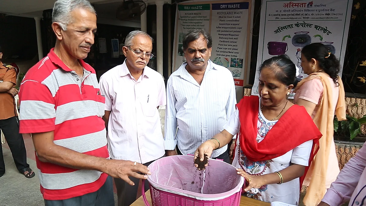 A volunteer from Asmita NGO demonstrates the technique of using compost basket to residents.