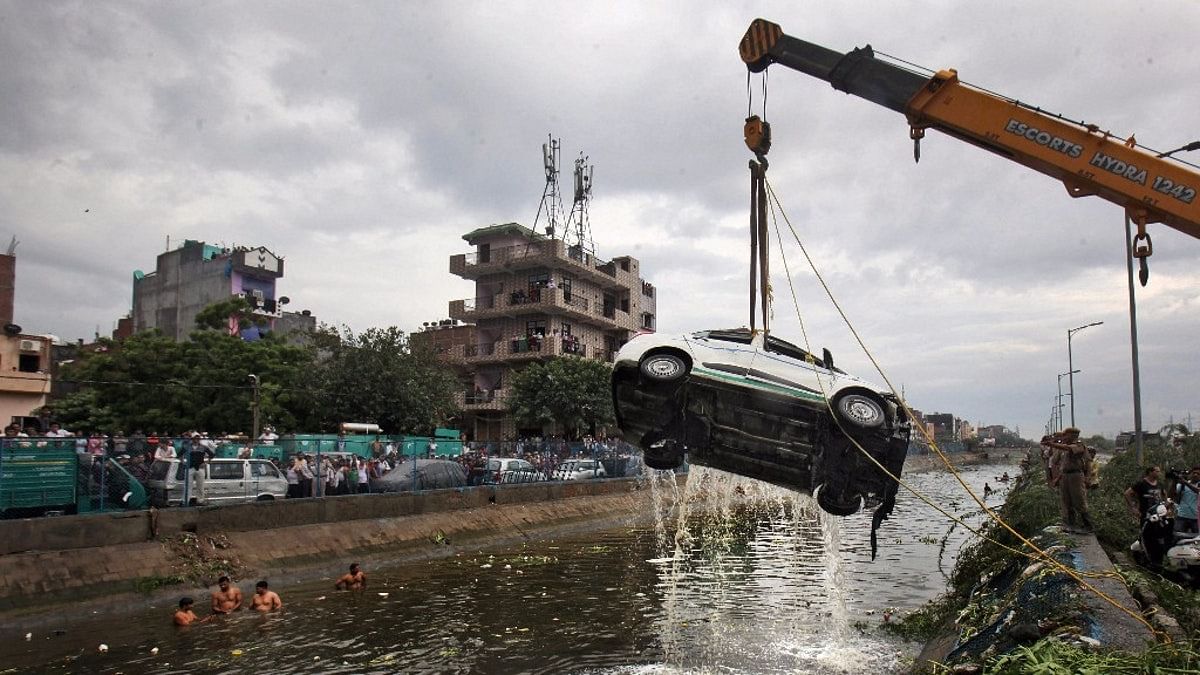 A car being pulled out of a canal as the rescue operations are underway after a part of the Ghazipur garbage landfill collapsed in east Delhi&nbsp;